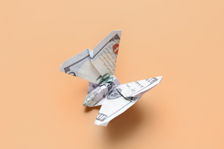 Origami butterfly made of dollar banknotes on beige backgroundの写真素材