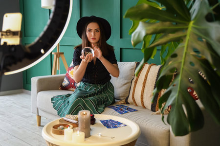 Young fortune teller recording video for blog at homeの写真素材