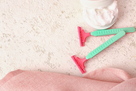 Colorful safety razors and shaving foam on light backgroundの写真素材