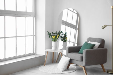 Interior of living room with mirror, armchair and tulips in vaseの写真素材