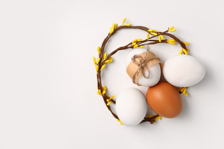 Easter eggs tied with string and floral decor isolated on white backgroundの写真素材