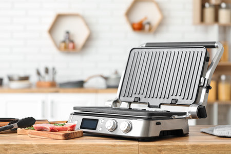 Modern electric grill on table in kitchenの写真素材