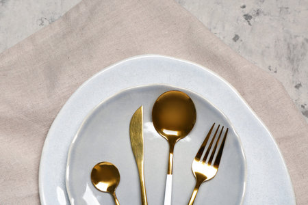 Plates with set of cutlery on gray grunge background