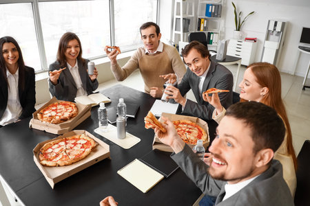 Group of business people with tasty pizza in officeの写真素材