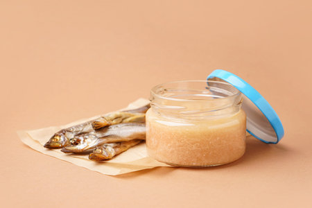 Jar of caviar and parchment with smoked capelin fish on brown backgroundの写真素材
