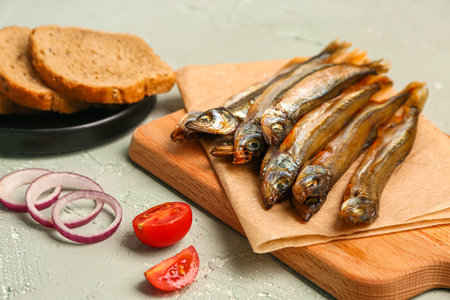 Board with tasty smoked capelin on gray backgroundの写真素材