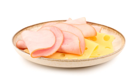 Plate with tasty slices of ham and cheese isolated on white backgroundの写真素材