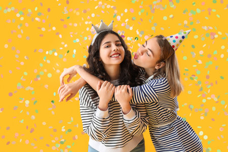 Happy young women celebrating Birthday on yellow backgroundの写真素材