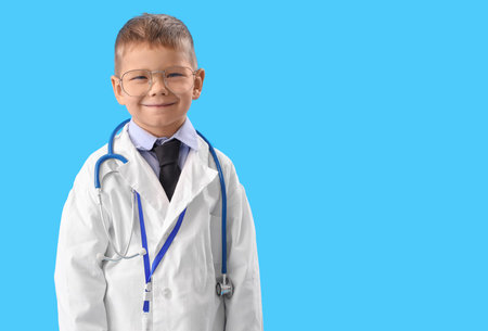Cute little doctor in eyeglasses on blue backgroundの写真素材