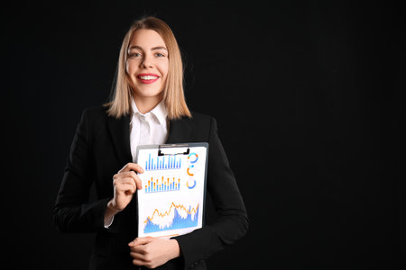 Female business consultant with clipboard on black backgroundの写真素材