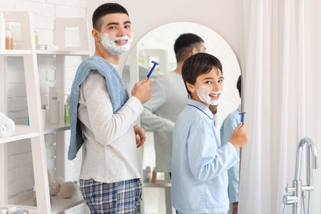 Morning of father and his little son shaving in bathroomの写真素材