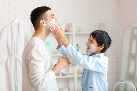 Morning of father and his little son shaving in bathroomの写真素材