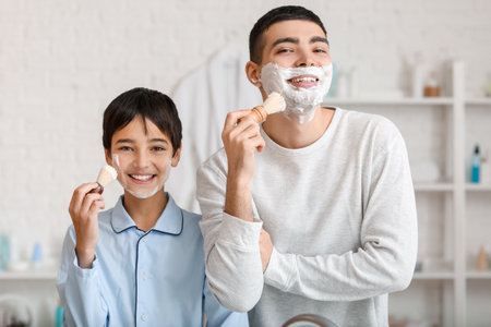 Morning of father and his little son shaving in bathroomの写真素材