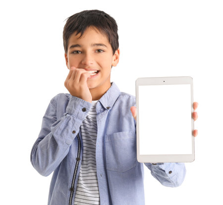 Little boy with tablet computer biting nails on white backgroundの写真素材