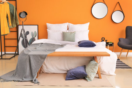 Stylish interior of room with bed and benchの写真素材