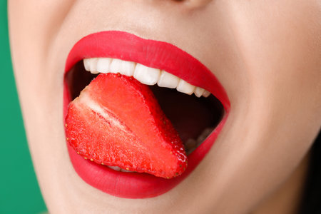 Sexy young woman with strawberry in mouth, closeupの写真素材