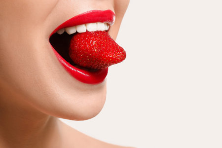 Sexy young woman with strawberry on white background, closeupの写真素材