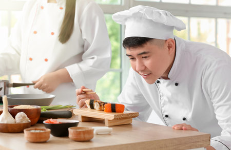 Handsome asian chef cooking in kitchenの写真素材