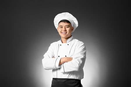 Handsome Asian chef on dark backgroundの写真素材