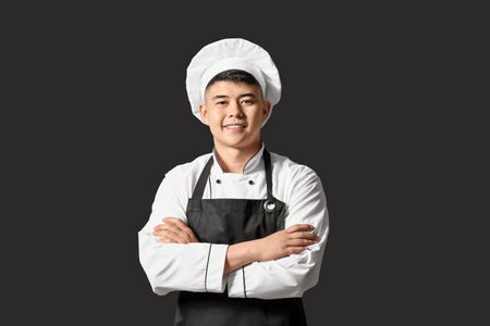 Handsome Asian chef on dark backgroundの写真素材