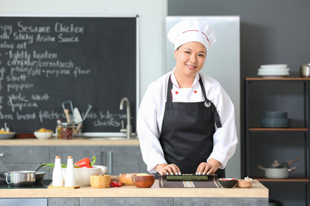 Beautiful Asian chef cooking in the kitchenの写真素材