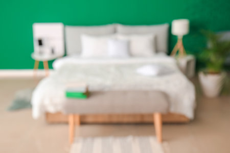 Big bed and bench in interior of modern room, blurred viewの写真素材