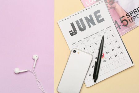 Mobile phone with calendar and magazine on color backgroundの写真素材
