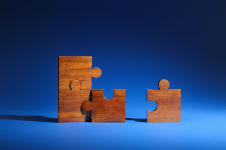 Wooden pieces of jigsaw puzzle on color background. unity conceptの写真素材