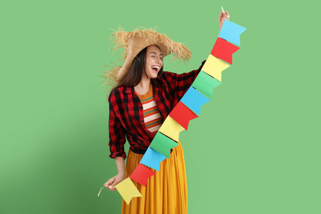 Young woman with flags on green background. Festa Junina (June Festival) celebrationの写真素材