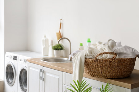 Basket with dirty clothes on counter in laundry roomの写真素材