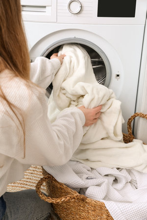 Woman dirty clothes in washing machine at home, closeupの写真素材