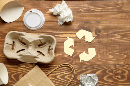 Recycling sign with garbage on wooden backgroundの写真素材