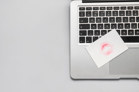 Laptop with lipstick kiss mark on gray background, closeupの写真素材