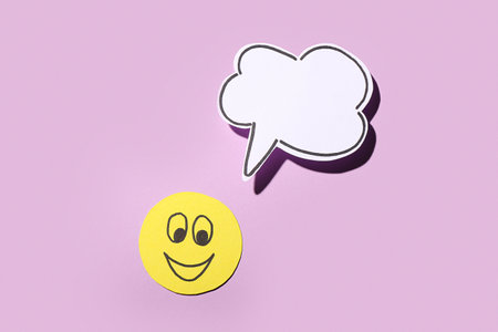 Paper smile with speech bubble on lilac background. Dialogue conceptの写真素材