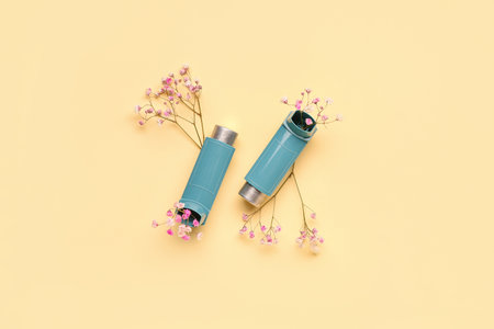 Asthma inhalers with flowers on yellow backgroundの写真素材