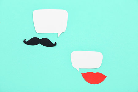 Paper mustache and lips with speech bubbles on mint background. Dialogue conceptの写真素材