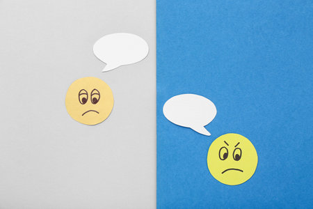 Paper faces with speech bubbles on color background. Dialogue conceptの写真素材