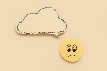 Sad smile with speech bubble on beige background. Dialogue conceptの写真素材