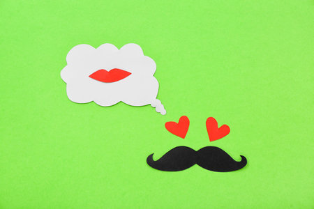 Paper male face and speech bubble with lips on green background. Dialogue conceptの写真素材