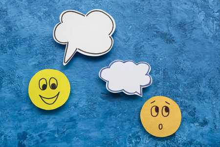 Paper faces with speech bubbles on grunge background. Dialogue conceptの写真素材