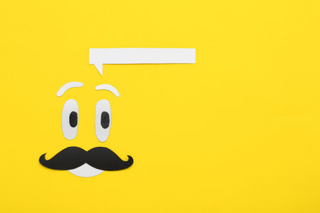 Paper male face with speech bubble on yellow background. Dialogue conceptの写真素材