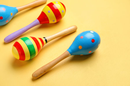Mexican maracas on yellow background, closeup
