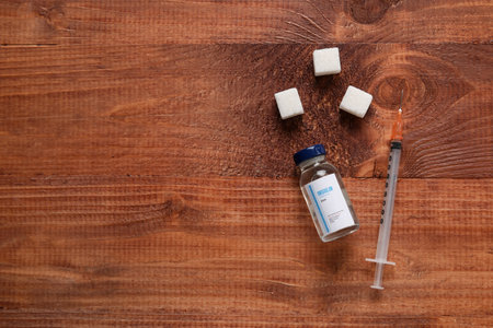 Insulin with syringe and sugar on wooden background. Diabetes conceptの写真素材