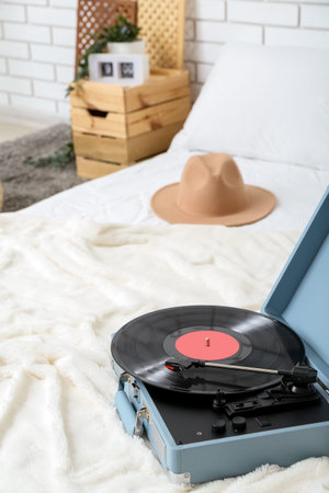 Record player with vinyl disk on bed in room, closeupの写真素材