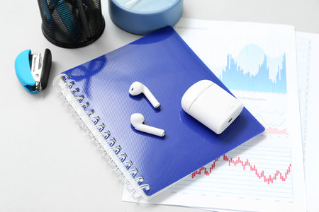 Composition with notepad, clock, stationery and earphones on light backgroundの写真素材