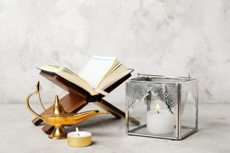 Muslim lantern with burning candles, Aladdin lamp and Koran on grunge backgroundの写真素材