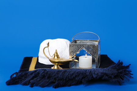 Muslim lantern with Aladdin lamp, hat and mat on blue backgroundの写真素材