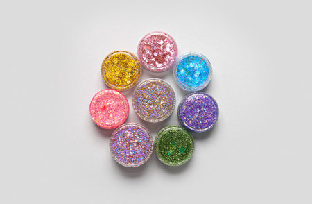 Jars of glitter on light background