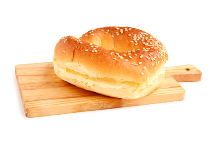 Wooden board of tasty bagel with cream cheese on white backgroundの写真素材