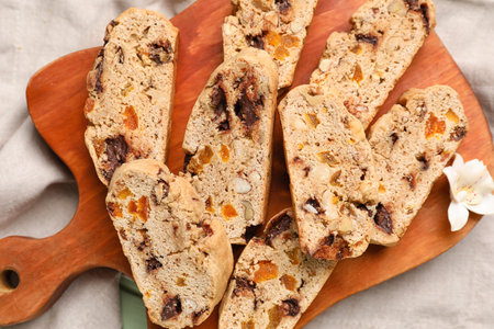 Wooden board with tasty biscotti cookies on fabric background, closeupの写真素材